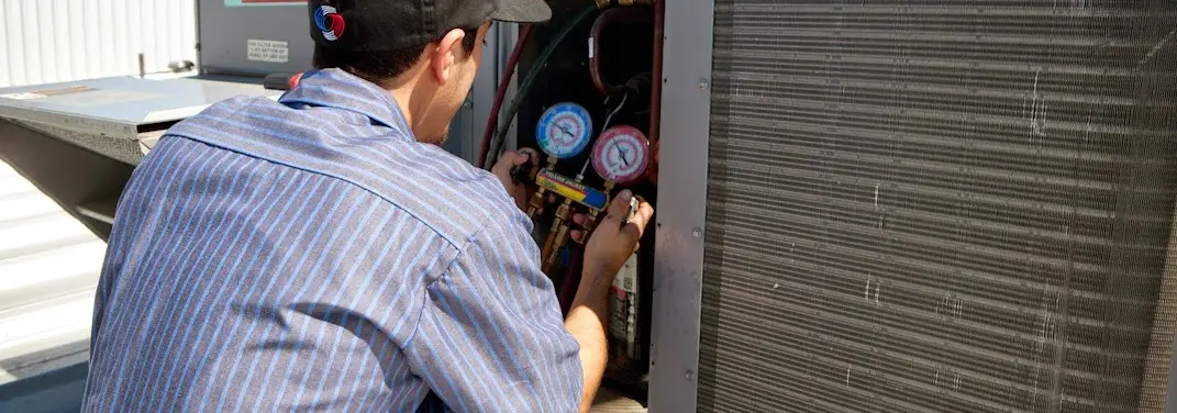 HVAC technician servicing a condenser unit in Magnolia