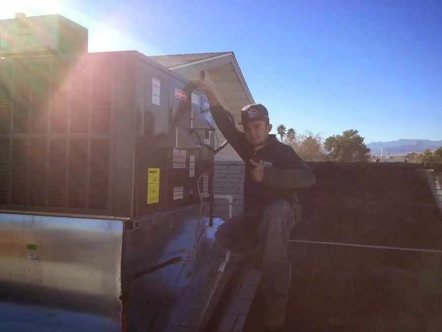 HVAC technician performing HVAC Inspection on a rooftop unit in Magnolia